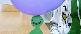 Naelektryzowany balon jest przyczepiony do ludzika wyciętego z kartonu