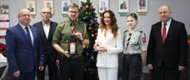 od lewej wicestarosta zambrowski, sekretarz powiatu, przedstawiciel Hufca Wschodniomazowieckiego ZHP, starosta zambrowski, przedstawiciel Hufca Wschodniomazowieckiego ZHP oraz kierownik PCPR w Zambrowie podczas przekazania Betlejemskiego Światła Pokoju