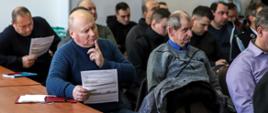 Na zdjęciu uczestnicy spotkania informacyjnego, którzy trzymają w dłoniach przykładowe wnioski o dofinansowanie.