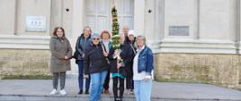Uczestnicy Klubu "Senior+", stojący przed Kościołem w Różanymstoku, prezentujący wykonaną palmę wielkanocną