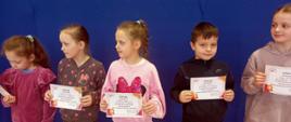 4 dziewczynki i 1 chłopiec - uczestnicy konkursu z klas 1-3 trzymają w rękach dyplomy zdobyte w konkursie