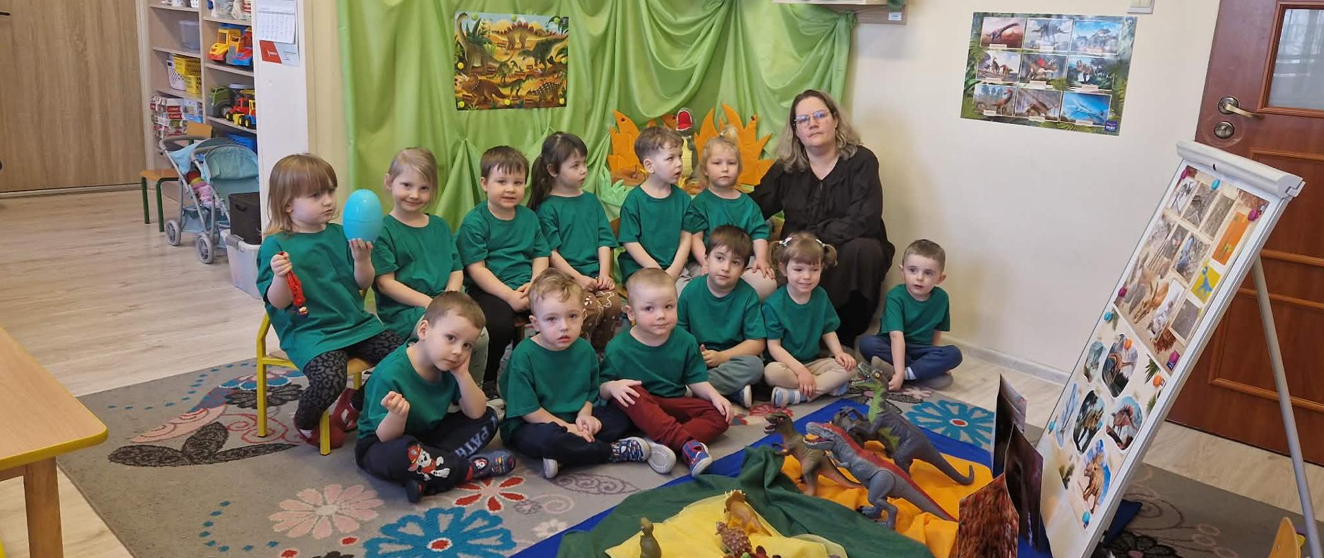 1 kobieta i 12 dzieci w zielonych koszulkach