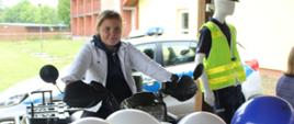 Dziewczynka siedzi na policyjnym quadzie, pozuje do zdjęcia