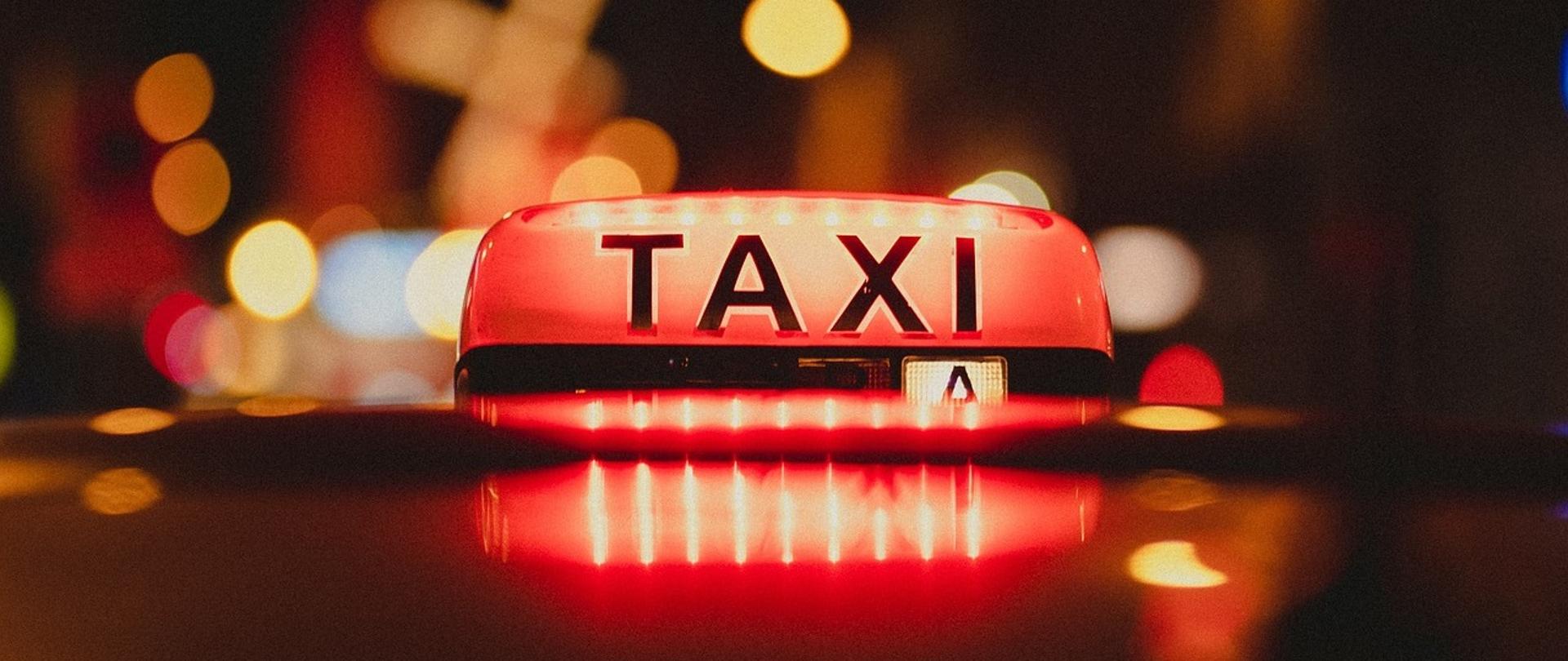 Zdjęcie napisu "Taxi" na samochodzie. Podświetlony na kolor czerwony