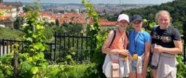 Trzy dziewczynki stoją na wzgórzu, z którego rozpościera się panorama Pragi