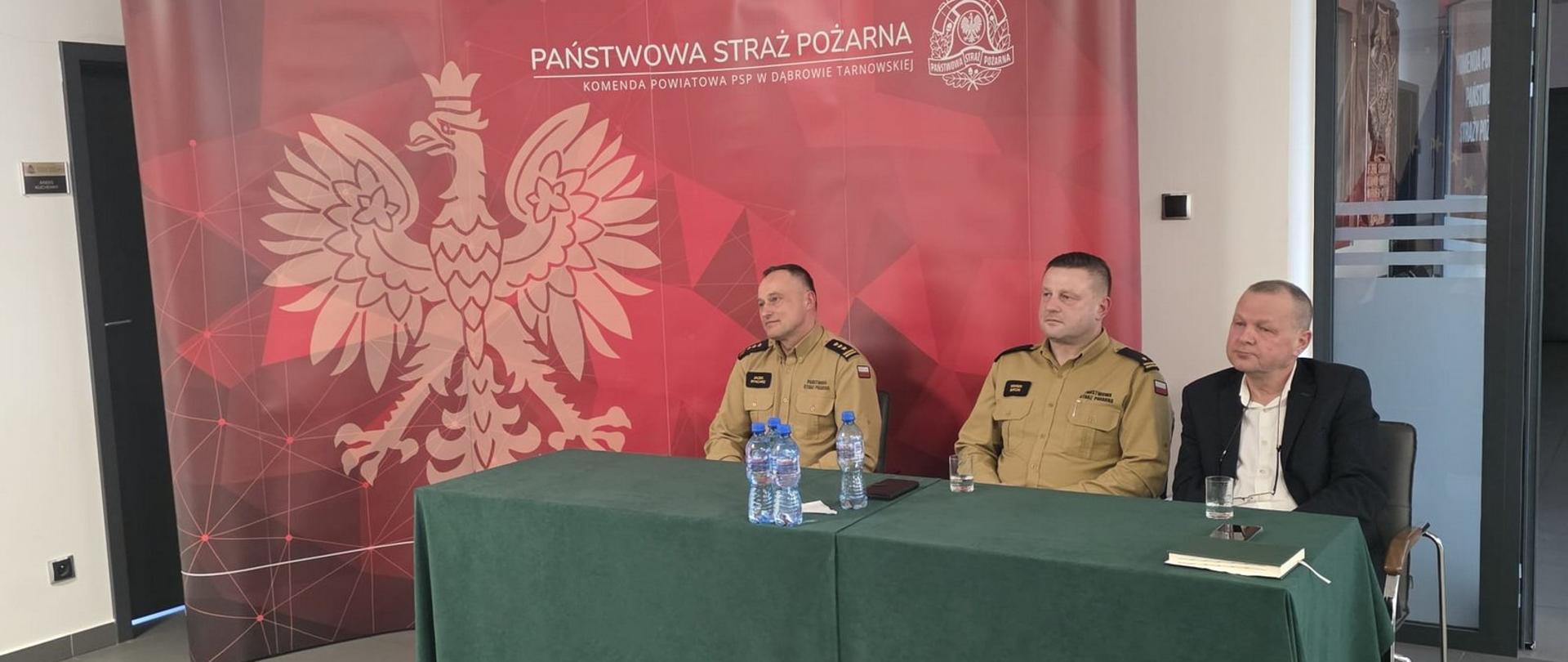 Starosta Dąbrowski, Zastępca Małopolskiego Komendanta Wojewódzkiego PSP oraz Komendant Powiatowy PSP siedzą przy stole konferencyjnym podczas 