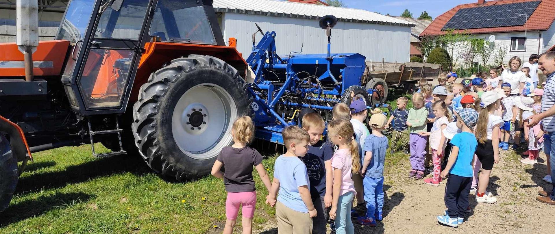 dzieci stoją obok traktora