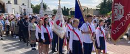 procesja przed kościołem z pocztem sztandarowym