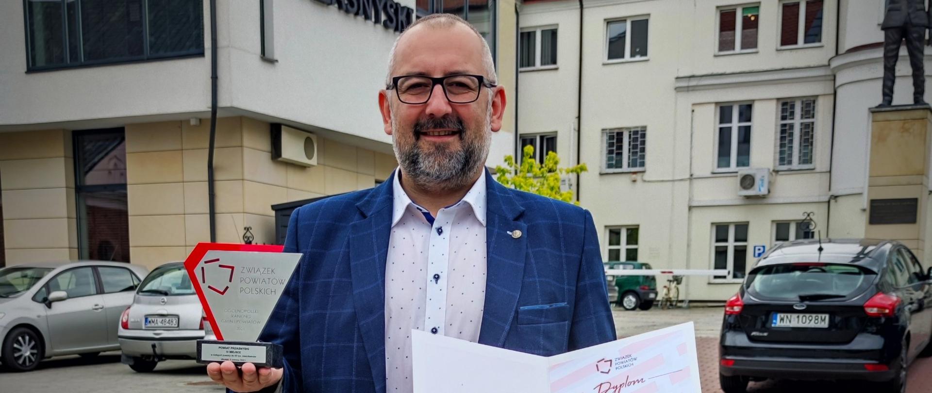 Na zdjęciu Starosta Przasnyski Krzysztof Bieńkowski trzyma w dłoniach pamiątkowe trofeum oraz dyplom za zajęcie przez Powiat Przasnyski czwartego miejsca w rankingu Związku Powiatów Polskich,
