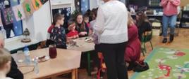 W trakcie warsztatów - przedszkolaki z bliskimi siedzą przy stołach