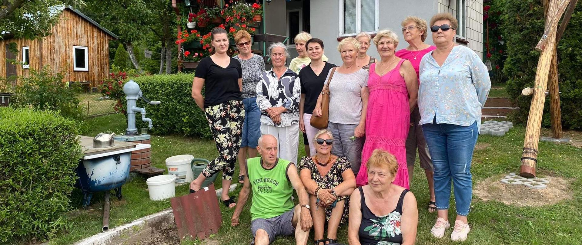 grupowe zdjęcie członków Klubu Senior+ wraz z pracownikami MOPS na działce, gdzie odbywał się grill