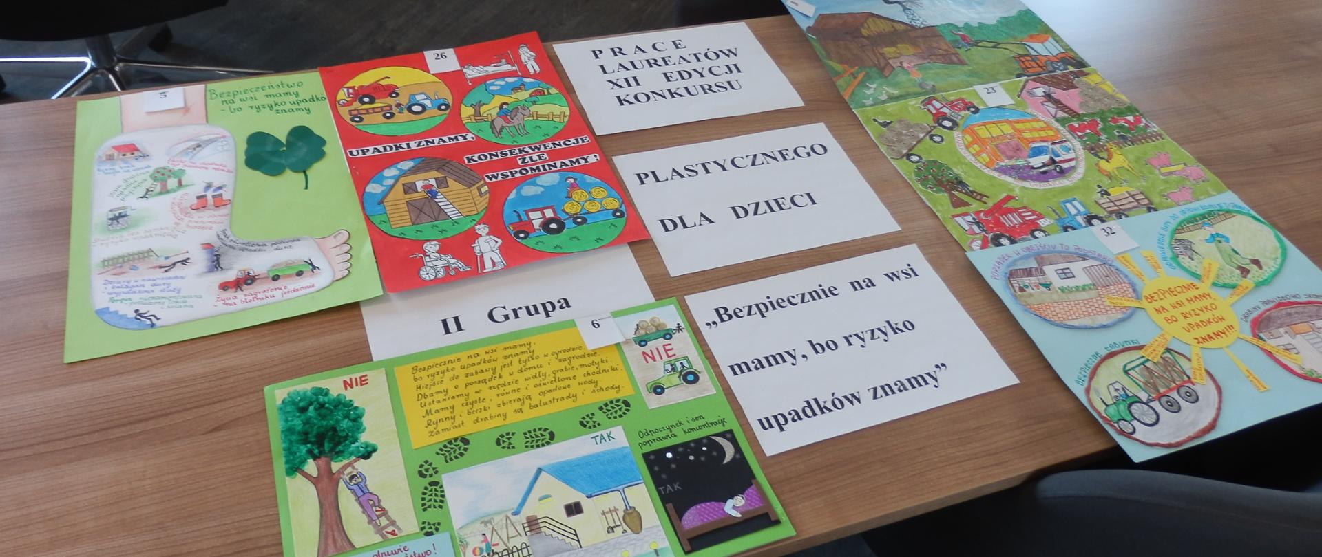 Zdjęcie przedstawia prace laureatów konkursu „Bezpiecznie na wsi mamy, bo ryzyko upadków znamy" rozłożone na sali konferencyjnej w budynki Starostwa Powiatowego w Przasnyszu.