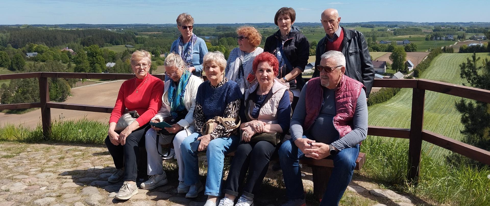 Członkowie Klubu Senior+ siedzący na ławce na Cisowej Górze