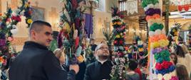 Konkurs palm w kościele w Rabie Wyżnej. Ksiądz ocenia piękne kolorowe palmy, ozdobione głównie kwiatami z bibuły.