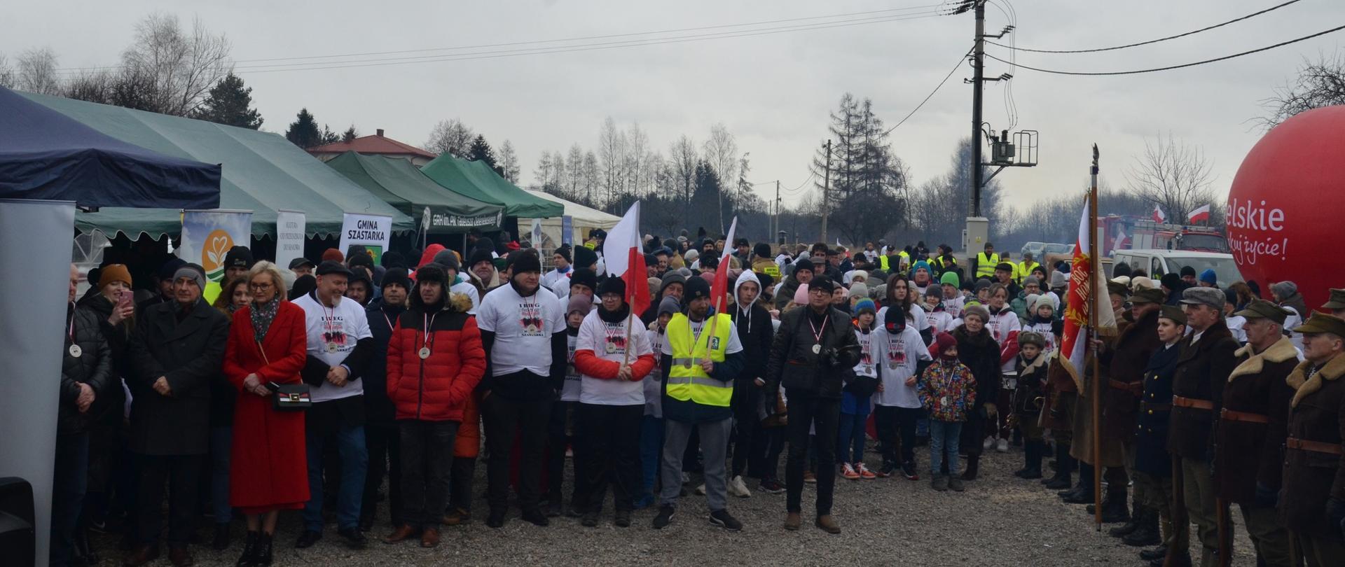 Na zdjęciu widzimy uczestników biegu którzy ustawieni są w rzędzie do zdjęcia 