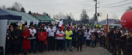 Na zdjęciu widzimy uczestników biegu którzy ustawieni są w rzędzie do zdjęcia 