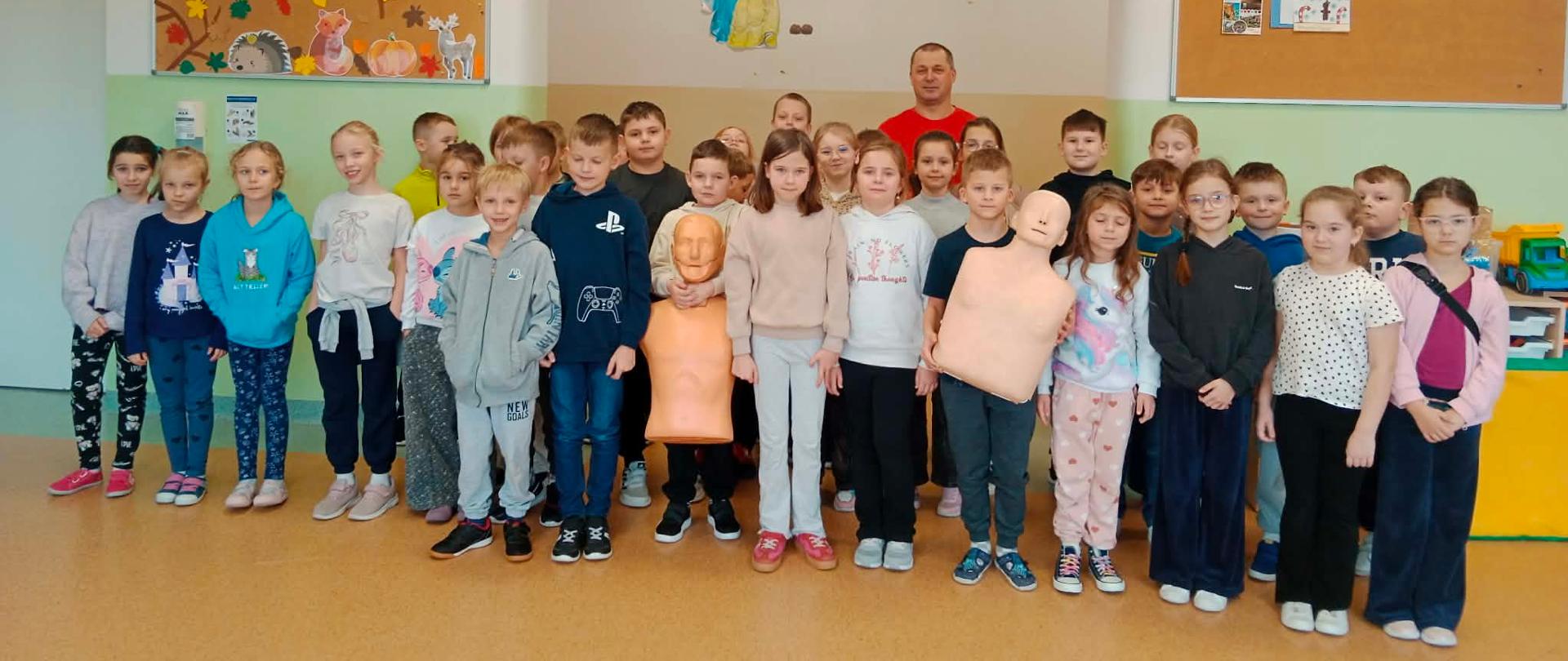 Uczniowie klasy IIa i IIb z ratownikiem i fantomami.