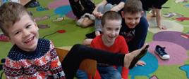 Dzieci w trakcie zabawy - malowanie stóp, które są odbijane na kartkach