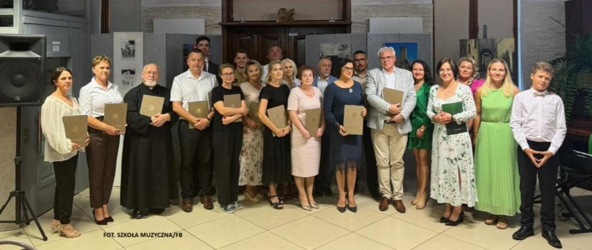 Fotografia grupowa wykonana z okazji spotkania w związku z Czytaniem Narodowym 2024 w Miejskiej Bibliotece Publicznej w Sokołowie Podlaskim. Na zdjęciu wicestarosta, burmistrz Miasta Sokołów Podlaski, przedstawiciele instytucji, duchowieństwa, szkół i przedszkoli.