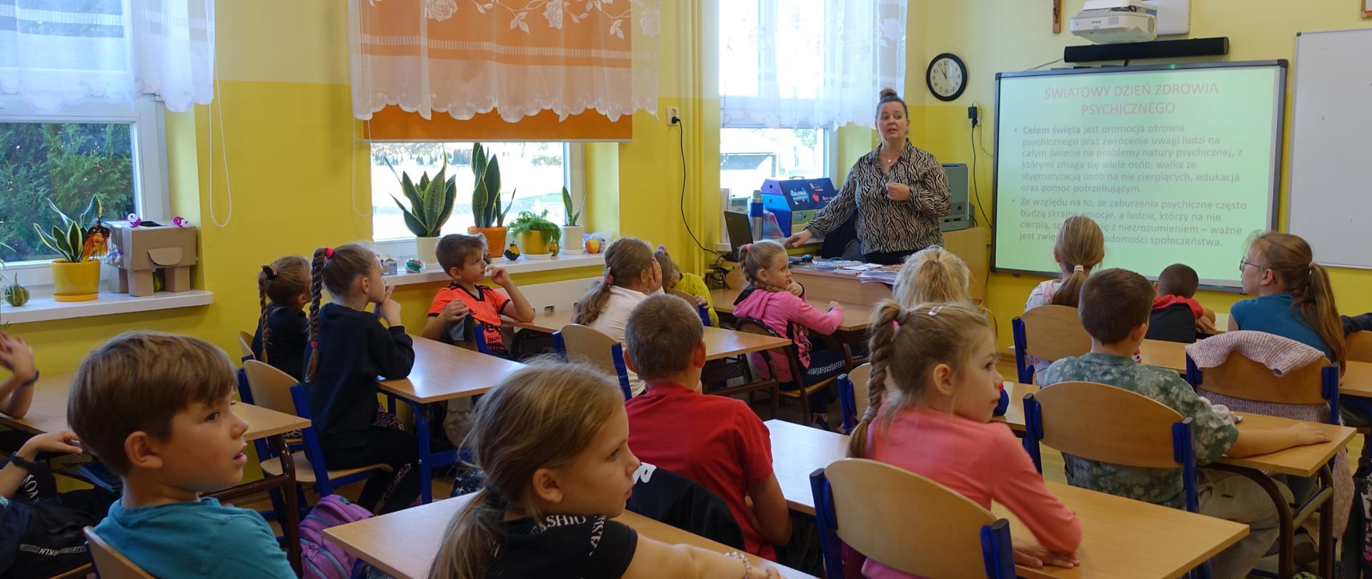 Uczniowie klas młodszych zebrani w sali lekcyjnej - prelekcja pedagoga szkolnego