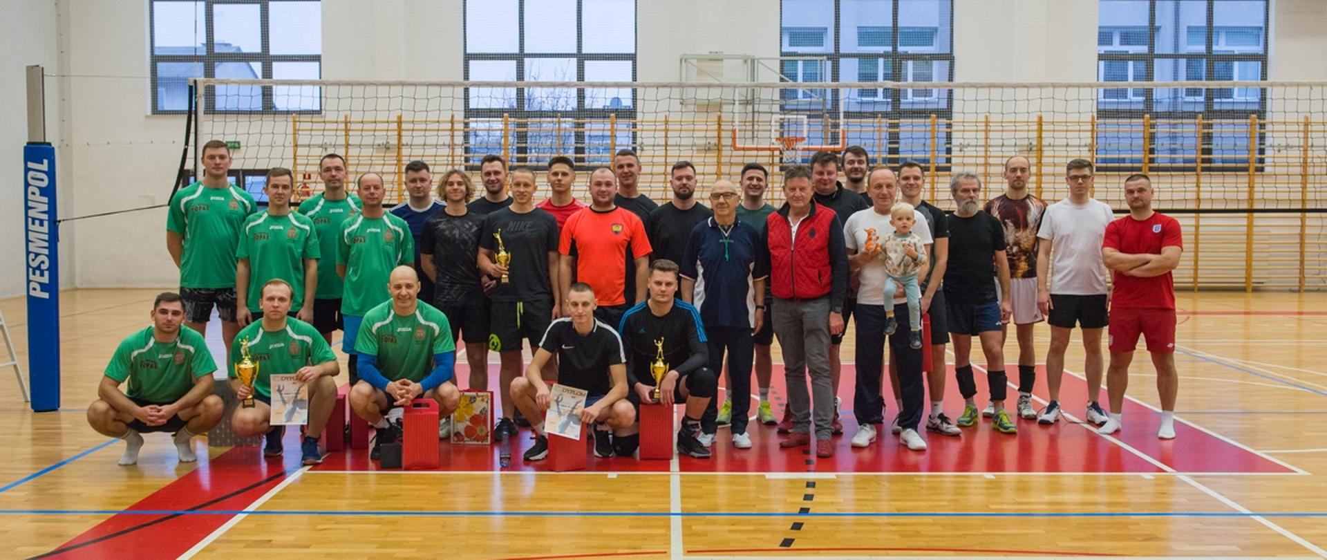Fotografia wykonana w hali sportowej ZS Nr 1 im. K.K. Baczyńskiego w Sokołowie Podlaskim. Do zdjęcia pozują wszystkie drużyny biorące udział w turnieju, organizatorzy oraz sędziowie..