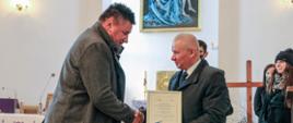 Starosta Kraśnicki Andrzej Rolla wręcza podziękowania przedstawicielowi firmy APPIA, za transport chóru i orkiestry z gminy Szastarka na charytatywny koncert "Solidarni z Ukrainą".