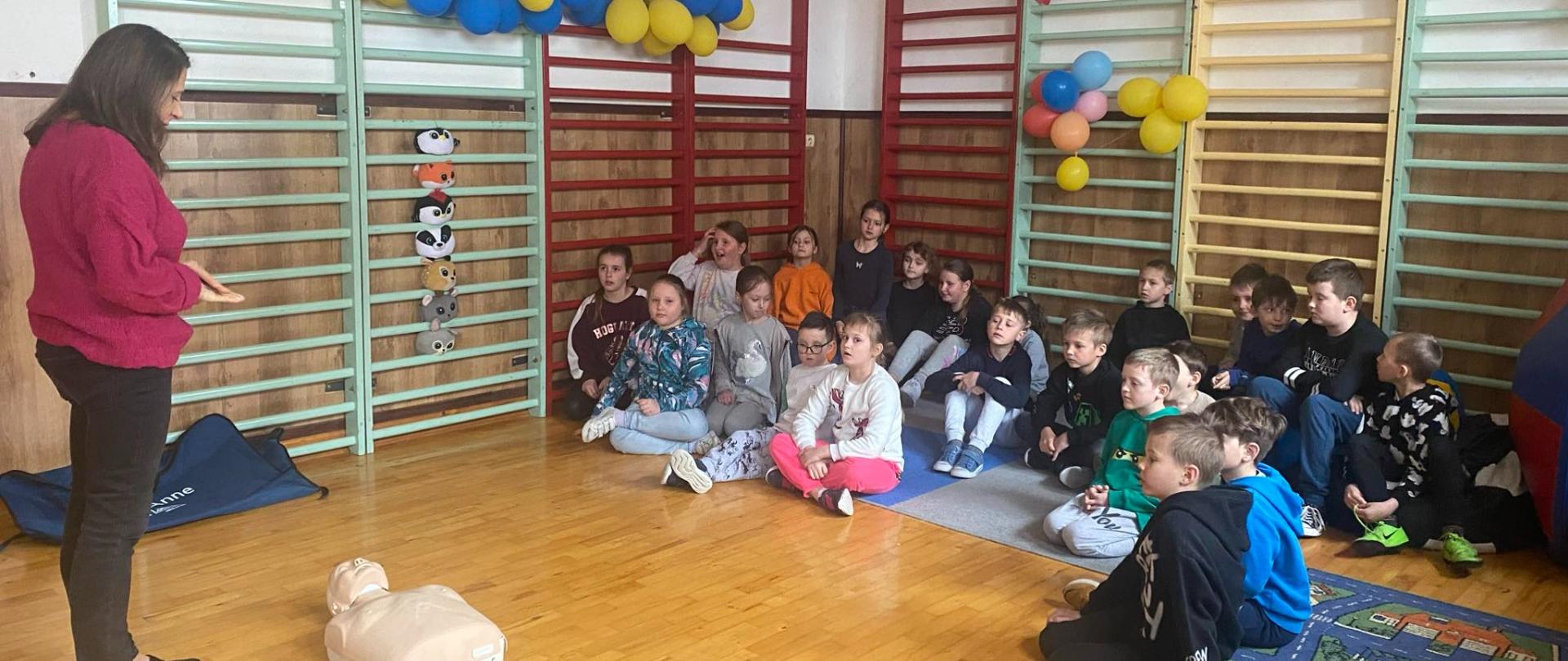 Uczniowie klasy III w sali świetlicy szkolnej uczestniczą w zajęciach z zakresu pierwszej pomocy przedmedycznej, przygotowanych i prowadzonych przez Panią pielęgniarkę szkolną.