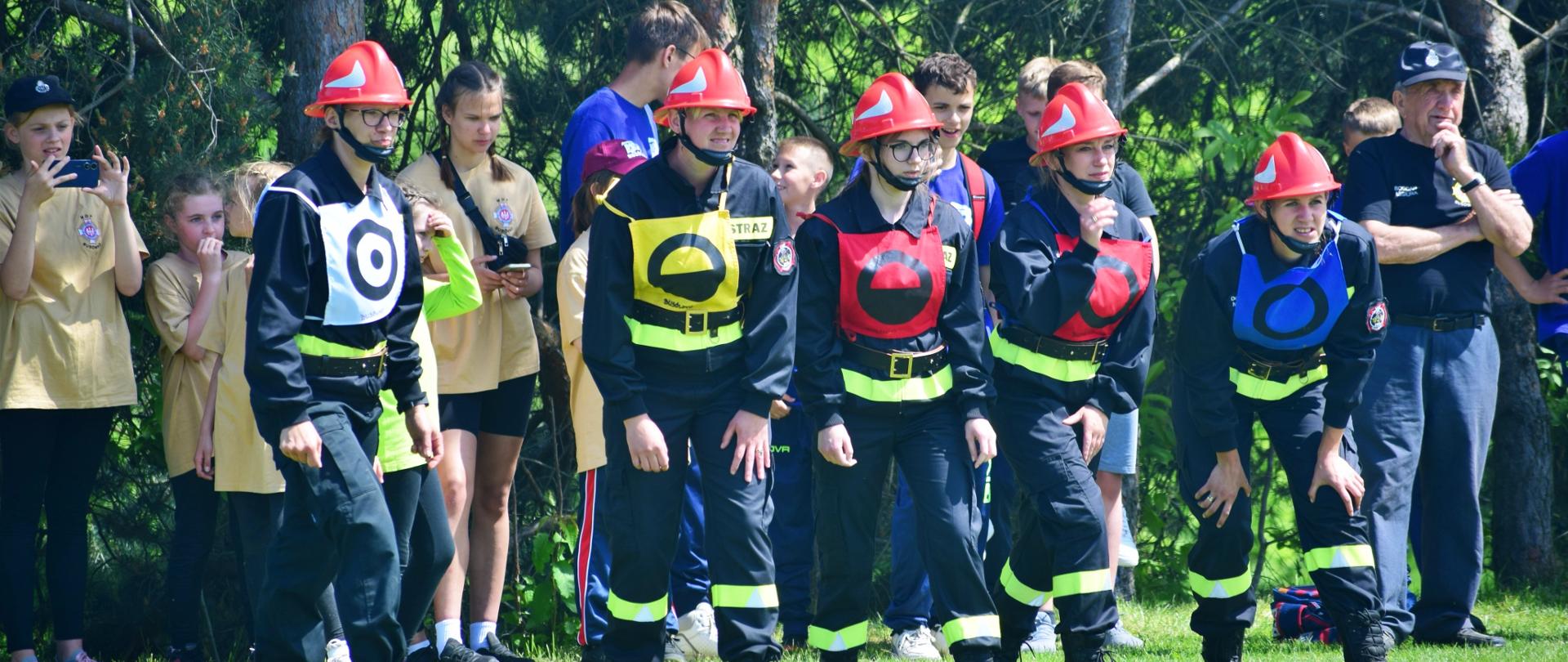 strażacy podczas wykonywania konkurencji w zawodach sportowo-pożarniczych