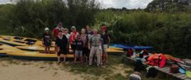 Zdjęcie uczestników spływu na tle kajaków