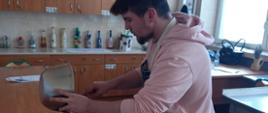 Uczeń przygotowuje potrawę - wylewa ciasto do formy