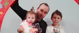 Rodzice pozują z dzieckiem do wspólnego zdjęcia, prezentują efekty warsztatów