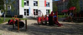 Plac zabaw, w tle nowy budynek przedszkola 