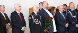 Fotografia grupowa przedstawicieli Senatu, samorządów oraz służb mundurowych.
Zdjęcie wykonane w garażu PSP w Sokołowie Podlaskim, podczas uroczystego pożegnania komendanta.