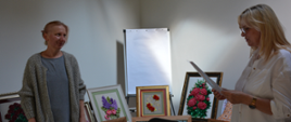 Wicestarosta i autorka wystawy na tle prezentowanych prac