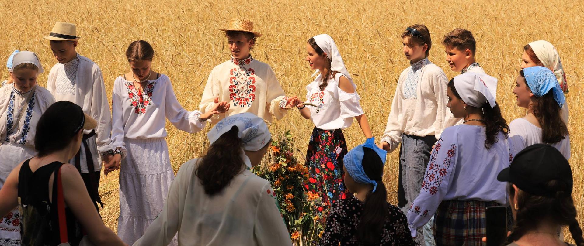 Uczestnicy wydarzenia w tradycyjnych strojach tańczą wokół "przepiórki" - obrzęd żniwny