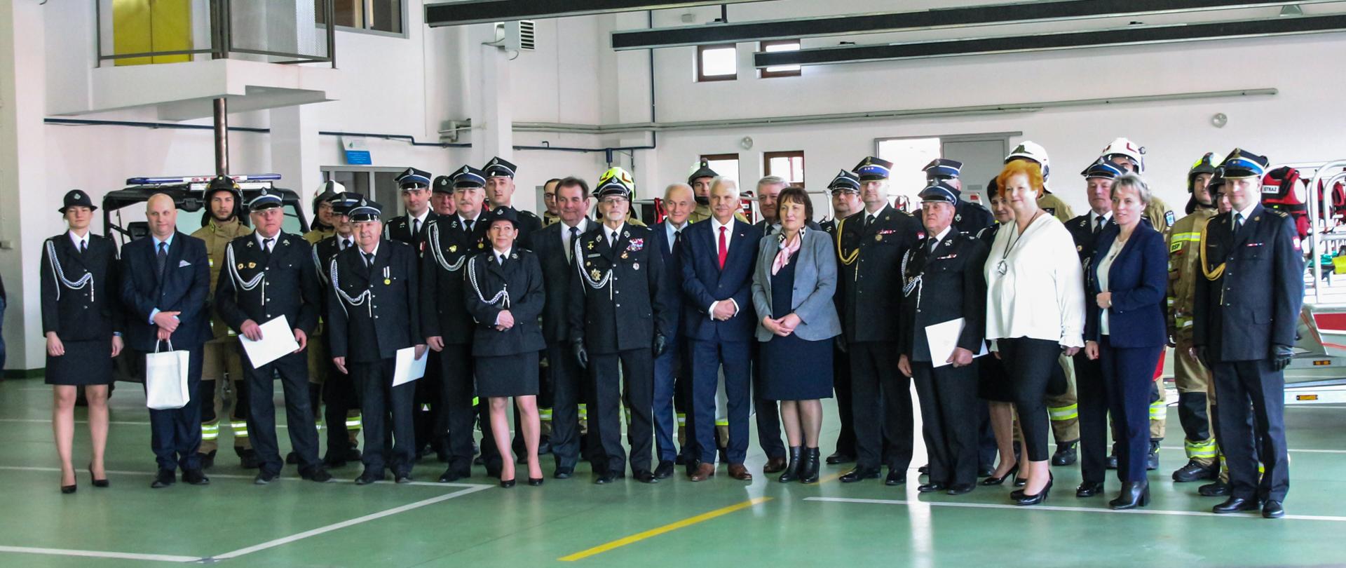 Zdjęcie grupowe na tle hangaru, a na nim zaproszeni goście, beneficjenci, strażacy, druhowie ochotnicy