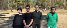 Na zdjęciu znajdują się trzy dziewczyny oraz chłopak. Wszyscy ubrani są w stroje sportowe. Za nimi rozpościera się las.