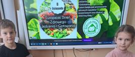 Uczniowie przy tablicy multimedialnej.