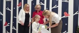 Dyrekcja Przedszkola wraz z przedstawicielką Nadleśnictwa Hajnówka wręczają nagrody dzieciom, pozując do wspólnego zdjęcia