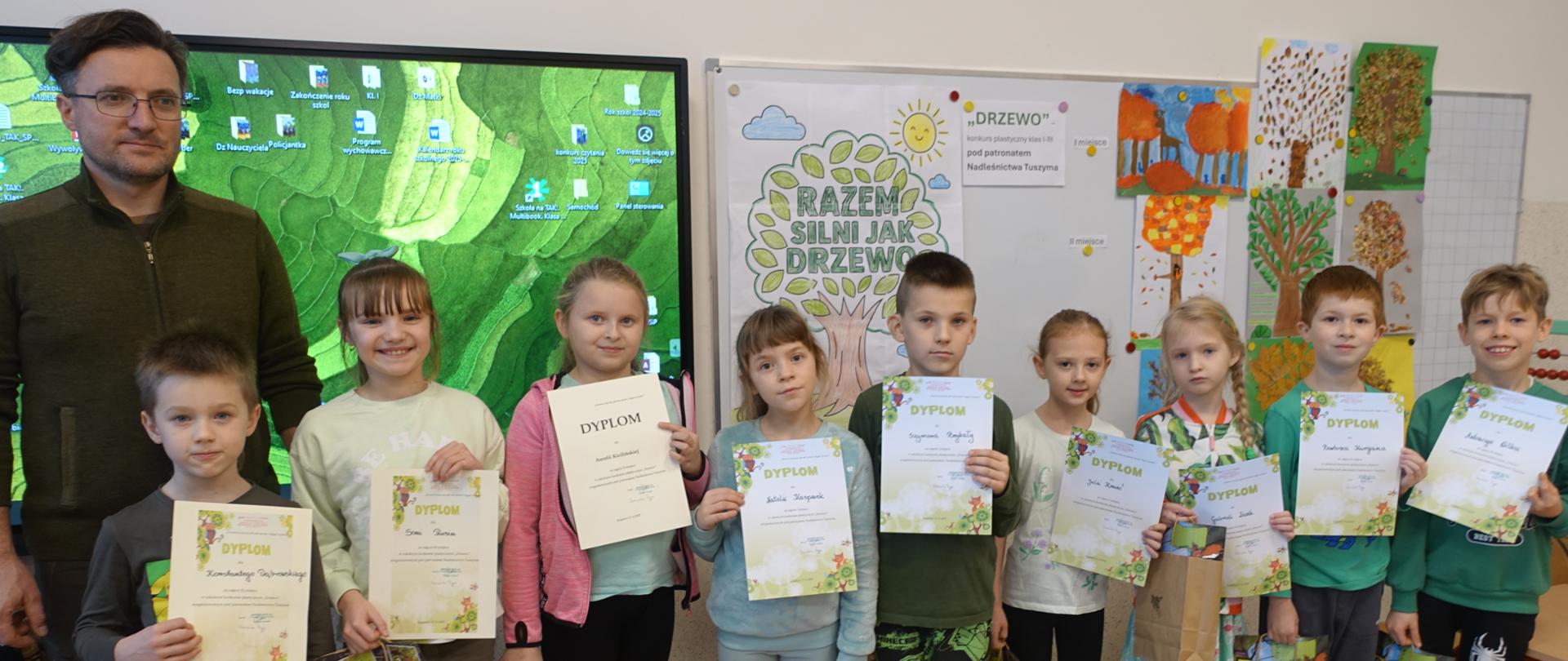 Pamiątkowe zdjęcie pana leśnika z autorami nagrodzonych prac