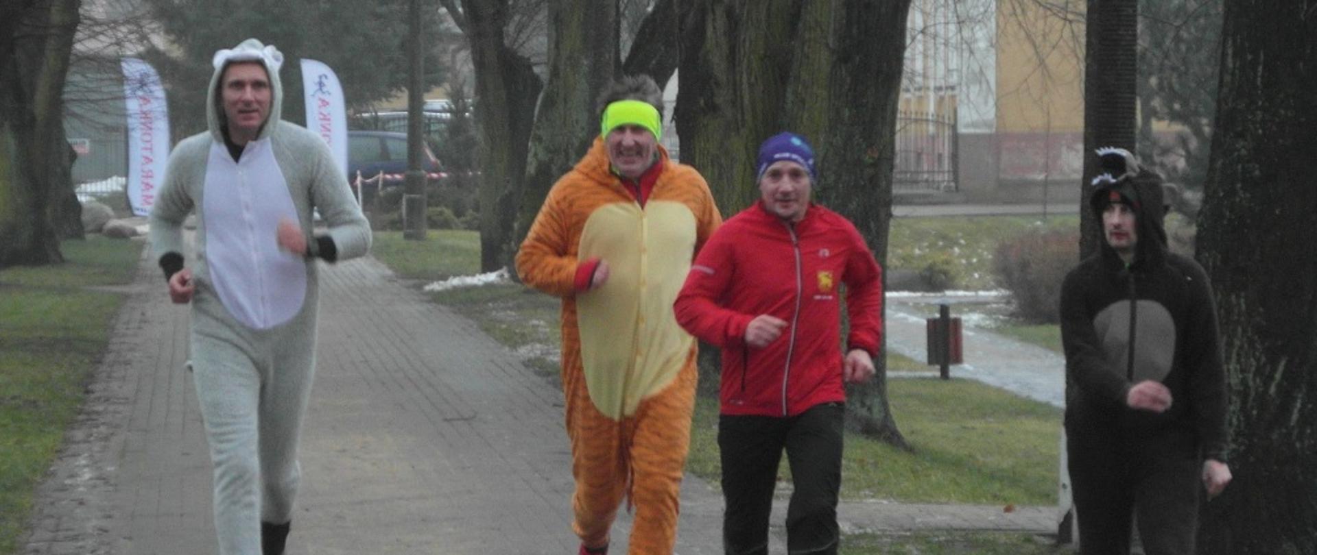 4 biegnących chodnikiem mężczyzn.