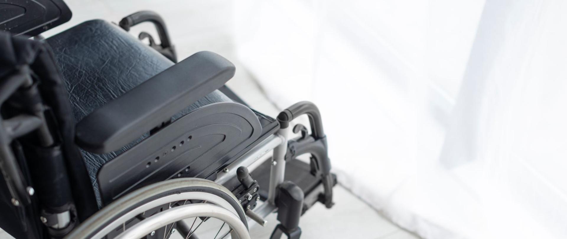 Wózek inwalidzki stojący przy oknie