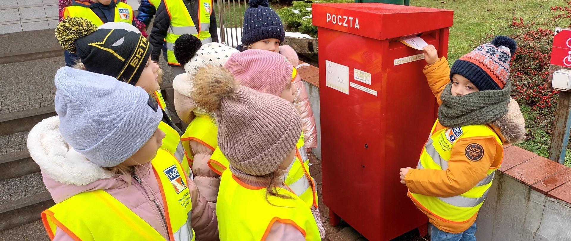 Dzieci wrzucają list do skrzynki pocztowej 