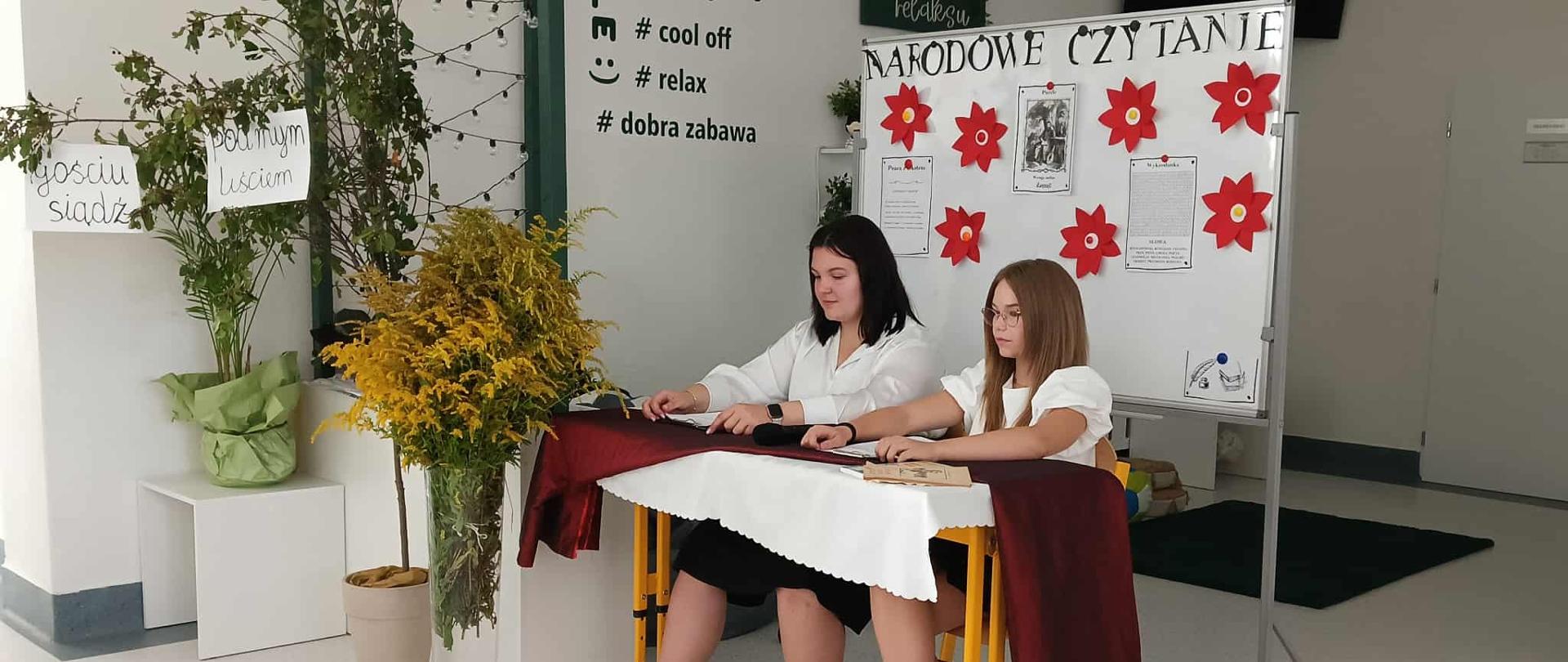Uczennice czytające książkę.