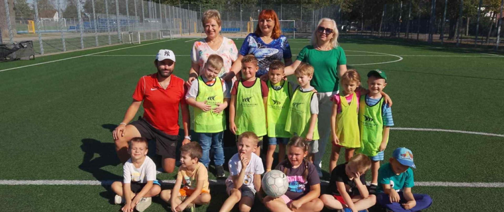 Przedszkolaki wraz z Dyrekcją, nauczycielkami i trenerem pozują do zdjęcia
