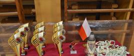 Stół dekoracyjny - puchary, medale, flaga Polski i znicz