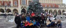 Uczniowie na rynku krakowskim przed pomnikiem Adama Mickiewicza.
