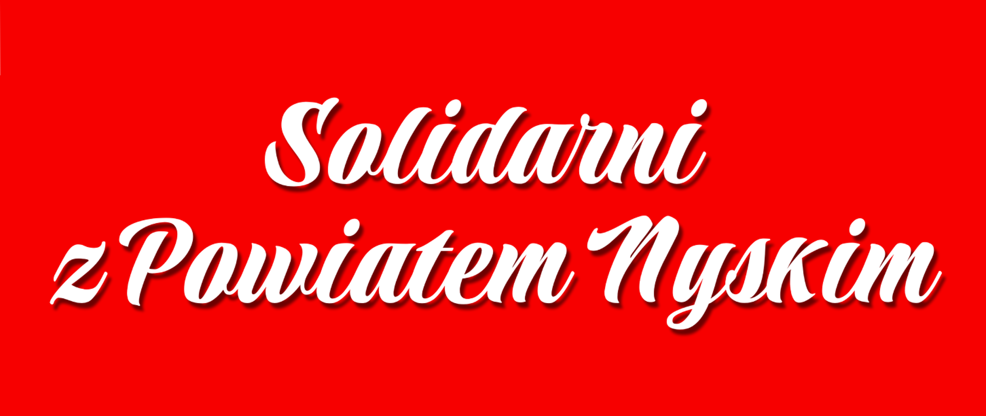 Baner o treści Solidarni z Powiatem Nyskim napisany białą, odręczną czcionką zamieszczoną na czerwonym tle.