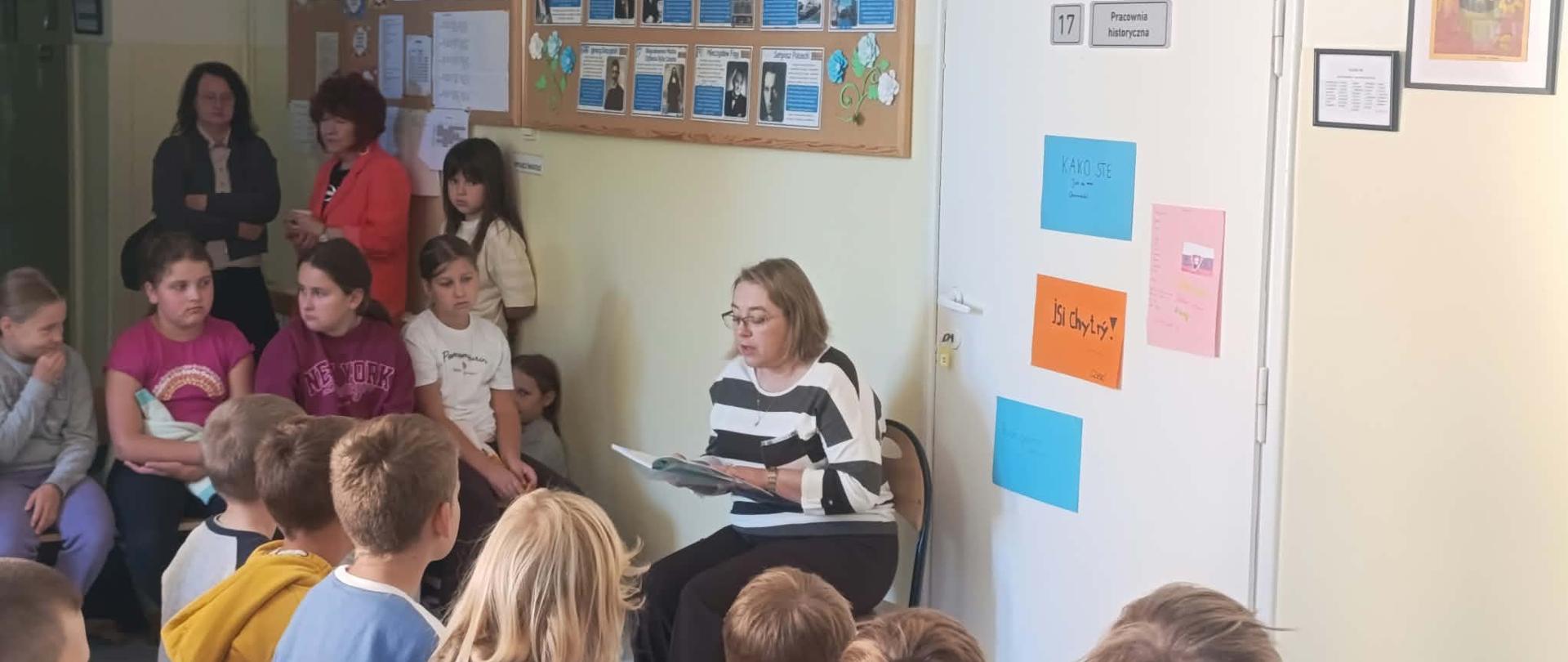 Uczniowie słuchają głośnego czytania podczas Ogólnopolskiej Akcji Głośnego Czytania.