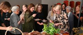 na zdjęciu znajdują się zaproszeni goście którzy degustują produktów podczas Uroczystych obchodów 20-lecia istnienia Stowarzyszenia Zambrowskiego Produkty Lokalne